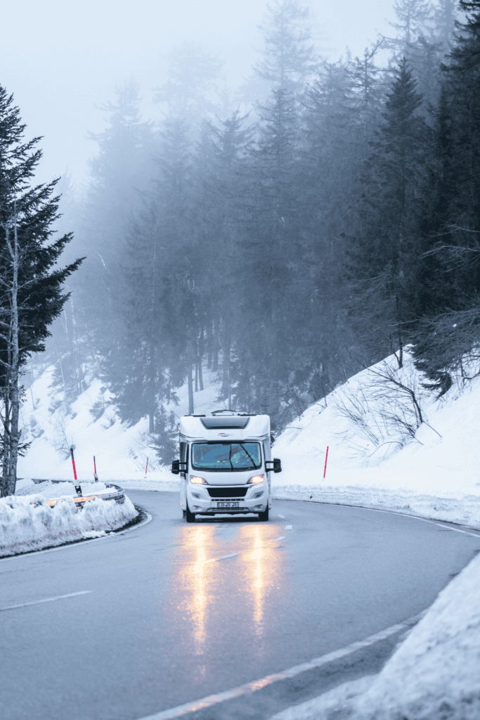 A motorhome driving on a snowy road in Scotland