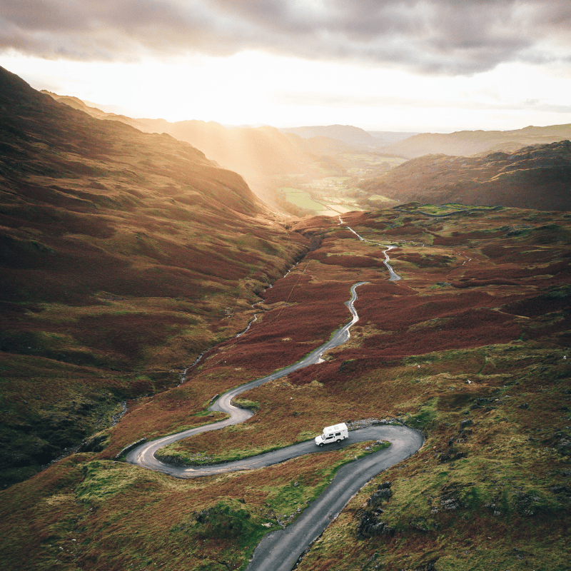 A motorhome driving on a road up a mountain in Scotland
